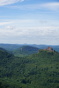 Landschaftsbild aus der Pfalz mit Blick in die Ferne, vorne rechts auf einem Hügel ist eine Burg zu sehen