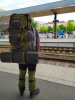 Erik steht mit vollgepacktem Wanderrucksack am Bahnhofsgleis