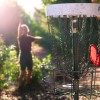 Disc Golf Spieler hat seine rote Frisbee erfolgreich in den Zielkorb geworfen. Disc Golf Spieler hat seine rote Frisbee erfolgreich in den Zielkorb geworfen.